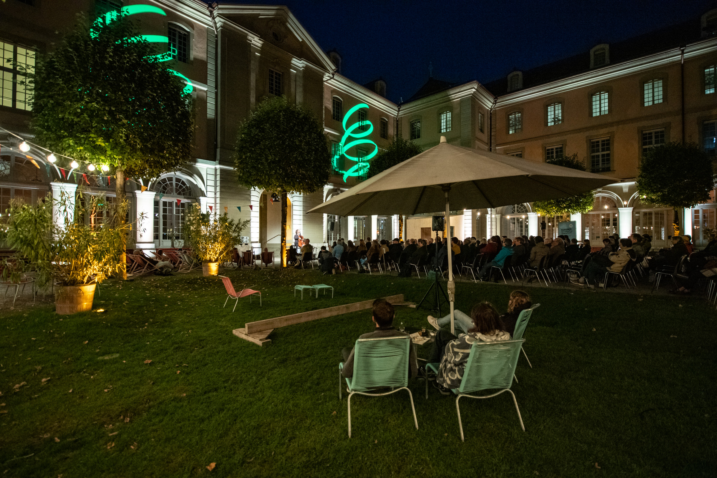 Abendveranstaltung ‚Reden zur Lage der Generationen‘ mit projiziertem Motiv an der Fassade des Berner Generationenhauses